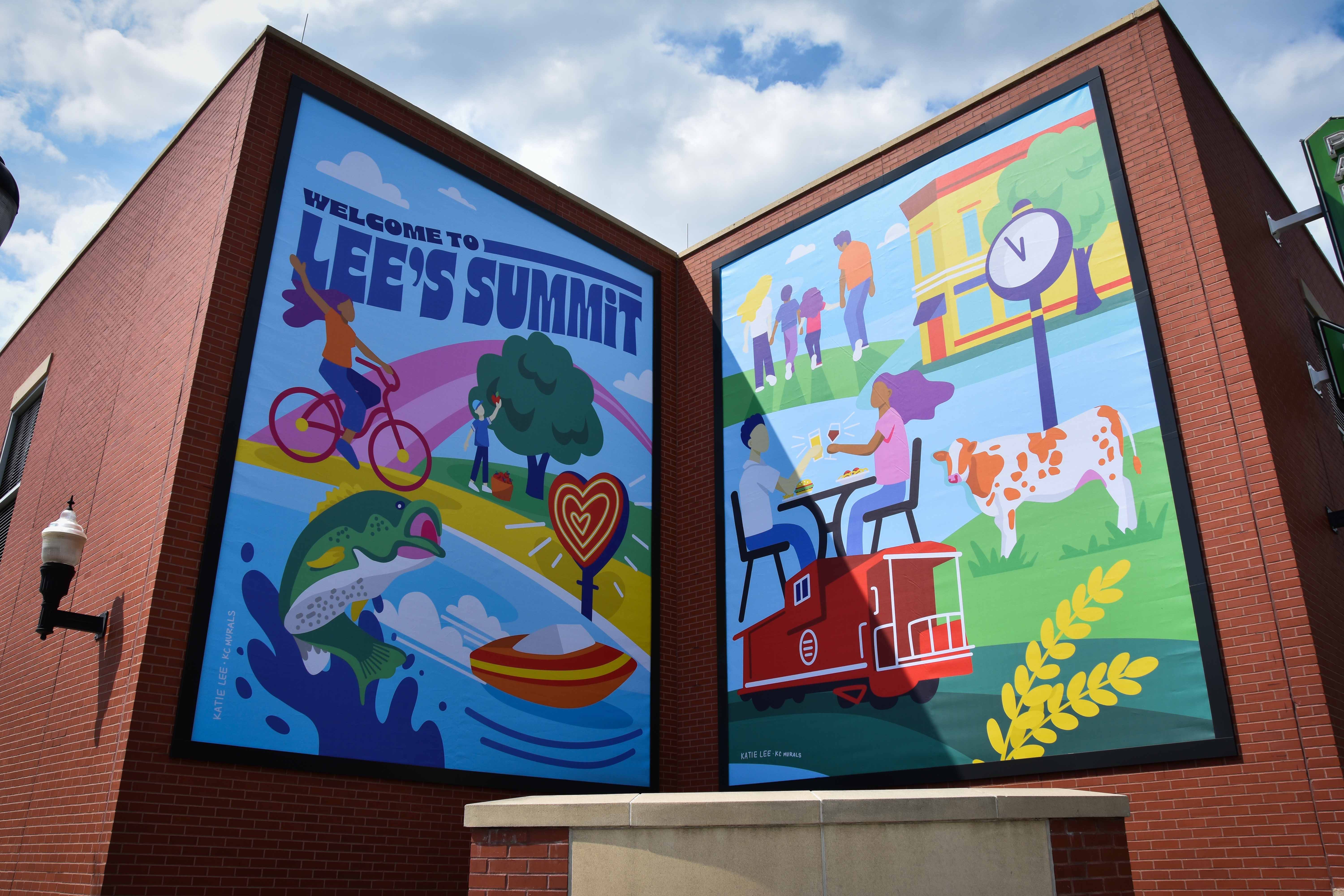exterior of a brick parking garage with two large murals saying welcome to lees summit